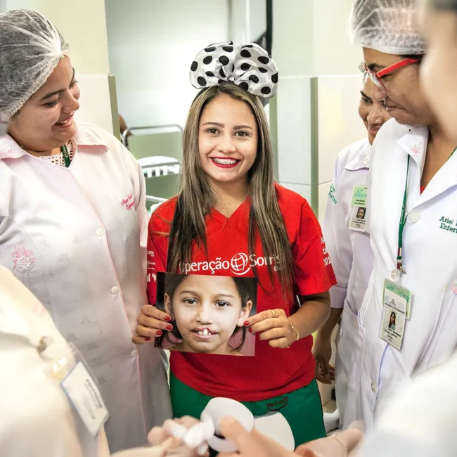 Antonia Sales (19 years old) holding her before surgery picture surrounded by hospital employees