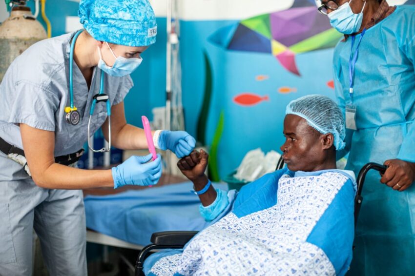 Female nurse shows patient his new smile through a mirror.