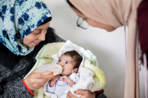 A person feeding a baby